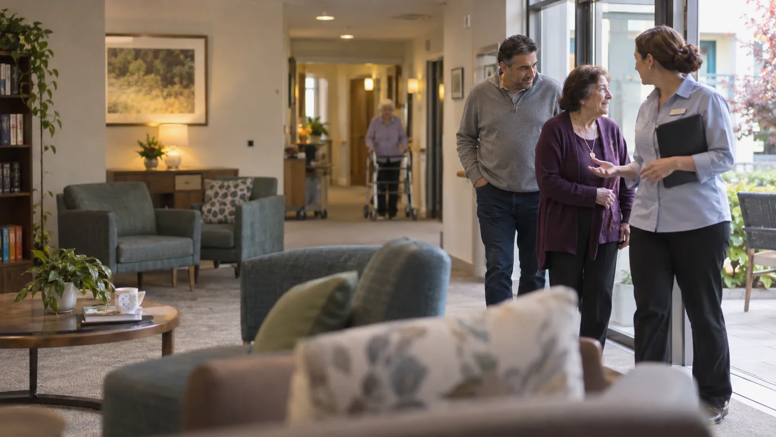 A family talking through aged care costs with an advisor in a facility lounge